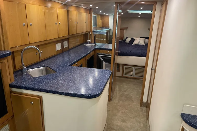 Slide: The Image of Luxurious 1990 Cary 50 yacht interior with modern kitchen and cozy bedroom. - 30