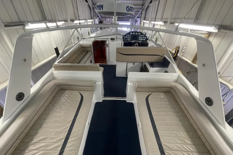 Slide: The Image of 1990 Cary 50 boat interior with beige seating and modern dashboard in a well-lit garage. - 12