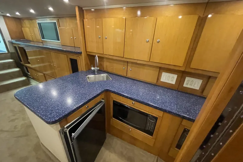 Slide: The Image of Luxurious 1990 Cary 50 yacht kitchen with blue countertops and wooden cabinetry. - 31