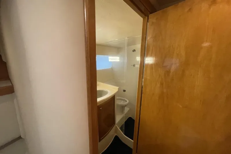 Slide: The Image of Compact bathroom in a 1990 Cary 50 boat, featuring wooden door and sink. - 36