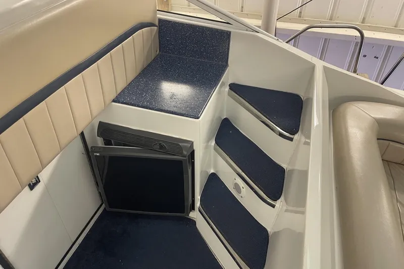 Slide: The Image of Interior of a 1990 Cary 50 boat featuring steps and a compact refrigerator. - 15