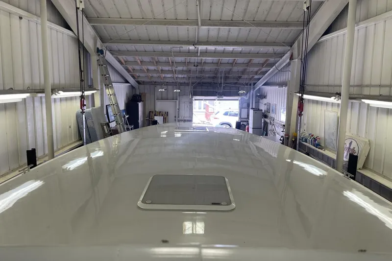 Slide: The Image of Roof of a 1990 Cary 50 boat inside a workshop with tools and equipment. - 26