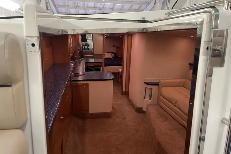 Slide: The Image of Interior of a 1990 Cary 50 yacht featuring a cozy cabin with kitchen and seating area. - 27
