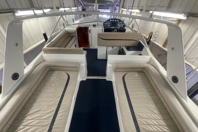 Slide: The Image of Interior view of a 1990 Cary 50 boat with beige seating and blue carpet. - 11