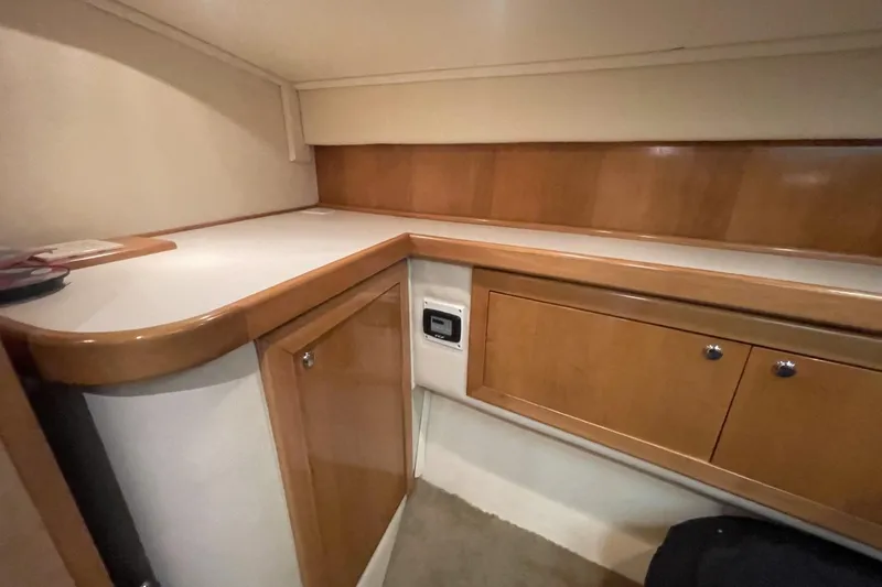 Slide: The Image of Interior of a 1990 Cary 50 boat with wooden cabinetry and white countertop. - 37
