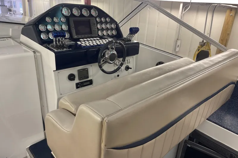 Slide: The Image of Cockpit of a 1990 Cary 50 boat with gauges, steering wheel, and beige seating. - 19