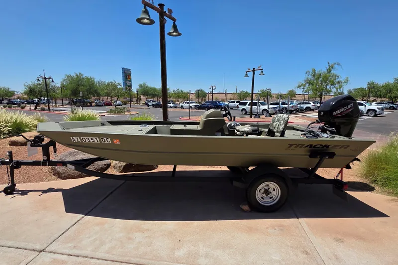 Slide: The Image of 2024 Tracker Grizzly 1754 SC boat on trailer in sunny parking lot. - 7