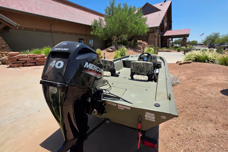 Slide: The Image of 2024 Tracker Grizzly 1754 SC boat with Mercury 40 engine, parked outdoors near a building. - 10