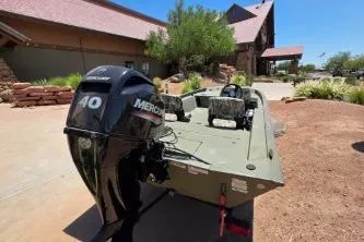 Slide: The Image of 2024 Tracker Grizzly 1754 SC boat with Mercury 40 engine, parked outdoors. - 4