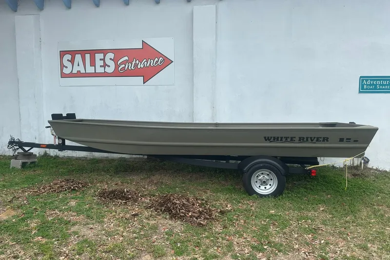Slide: The Image of 2025 White River TOPPER 1542 Jon Boat on trailer near sales entrance sign. - 0