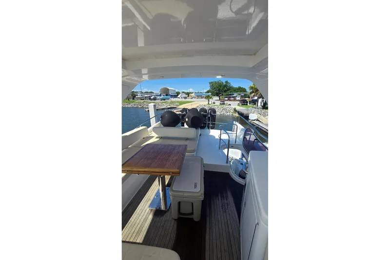 Slide: The Image of 2014 Azimut 54 yacht interior with seating and table, docked by the water. - 10