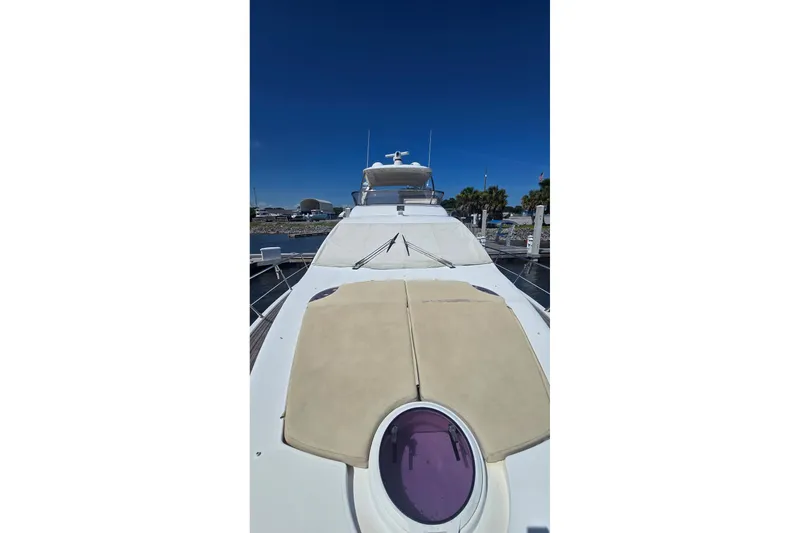 Slide: The Image of 2014 Azimut 54 yacht with sunbathing deck, docked under clear blue sky. - 11