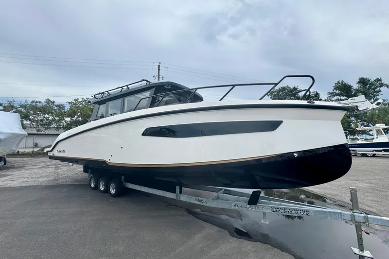 Slide: The Image of 2026 Navan C30 boat on trailer, sleek design, parked outdoors under cloudy sky. - 2