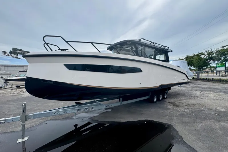 Slide: The Image of 2026 Navan C30 boat on trailer, sleek design, parked outdoors under cloudy sky. - 8