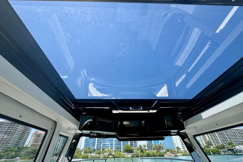 Slide: The Image of Interior view of 2026 Navan C30 boat with panoramic glass roof and cityscape background. - 35