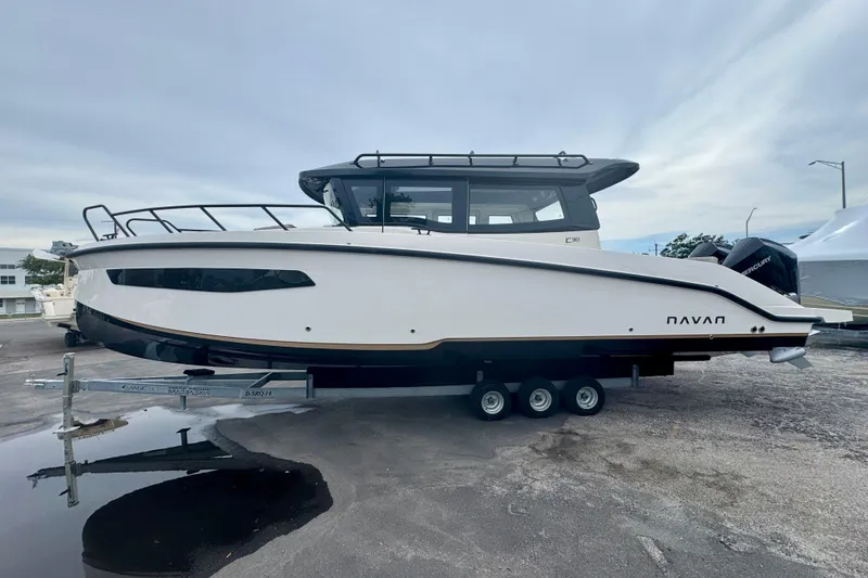 Slide: The Image of 2026 Navan C30 boat on trailer, sleek design, parked outdoors. - 9