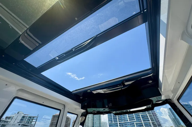 Slide: The Image of Sunroof view from 2026 Navan C30, showcasing clear blue sky and urban skyline. - 36