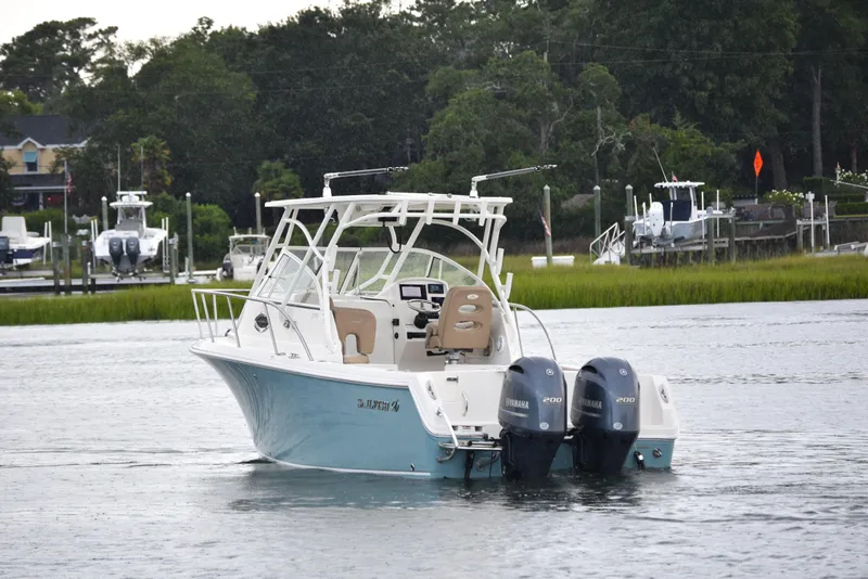 Slide: The Image of 2020 Sailfish 270 WAC boat with twin Yamaha engines on a calm waterway. - 1