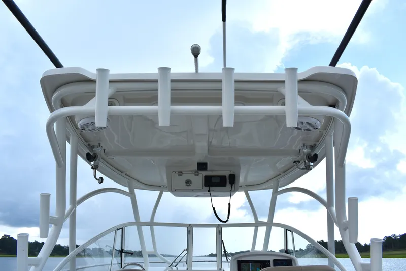 Slide: The Image of 2020 Sailfish 270 WAC boat helm with rod holders and electronics, under cloudy sky. - 12