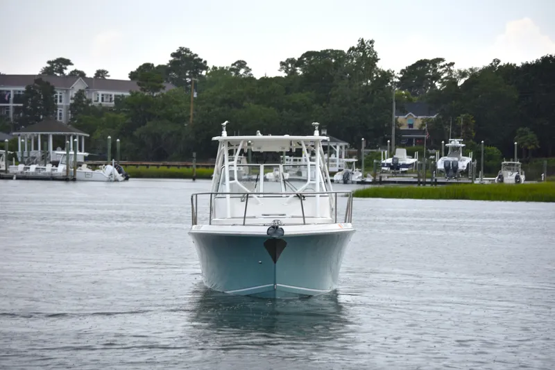 Slide: The Image of 2020 Sailfish 270 WAC boat cruising on a calm waterway near a marina. - 3