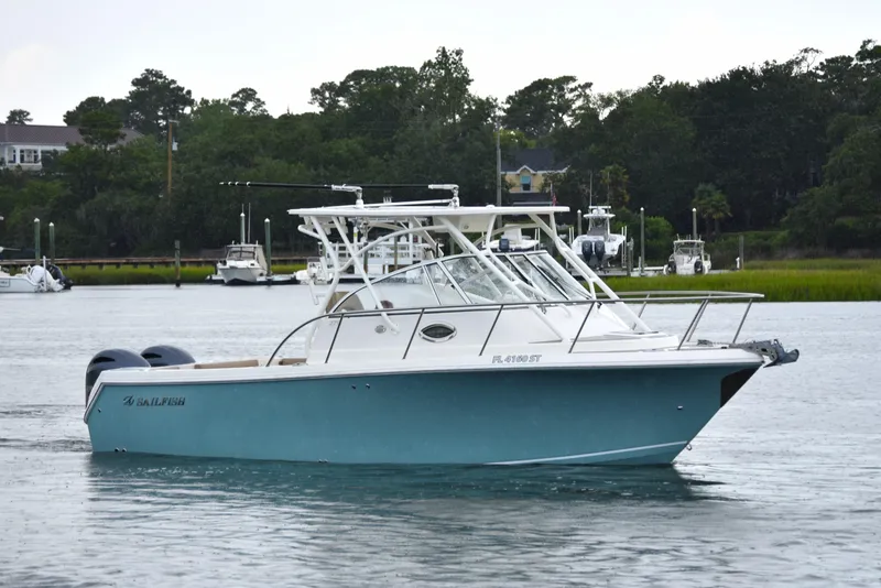 Slide: The Image of 2020 Sailfish 270 WAC boat cruising on a calm waterway with lush greenery in the background. - 5