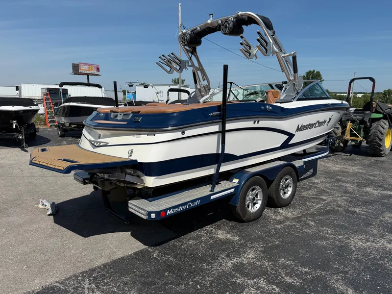 Slide: The Image of 2016 MasterCraft X30 on a trailer, featuring a tower and wakeboard racks. - 10