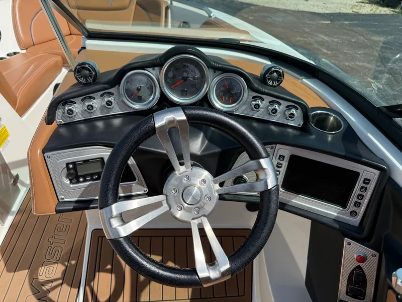 Slide: The Image of The image shows the dashboard of a 2016 MasterCraft X30 boat with modern gauges and a sleek steering wheel. - 40
