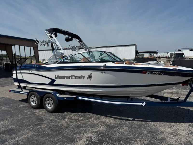 Slide: The Image of A 2016 MasterCraft X30 on a trailer, featuring sleek design and a tower for watersports. - 7