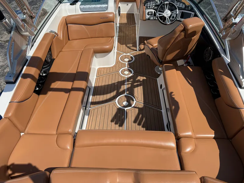 Slide: The Image of Interior of a 2016 MasterCraft X30 with brown leather seating and a modern helm. - 24