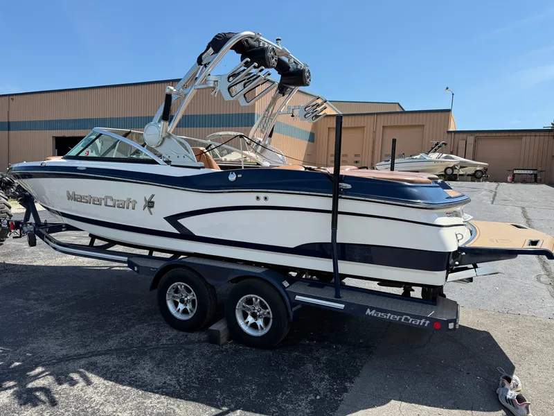 Slide: The Image of A 2016 MasterCraft X30 on a trailer, featuring a tower and wakeboard racks. - 13