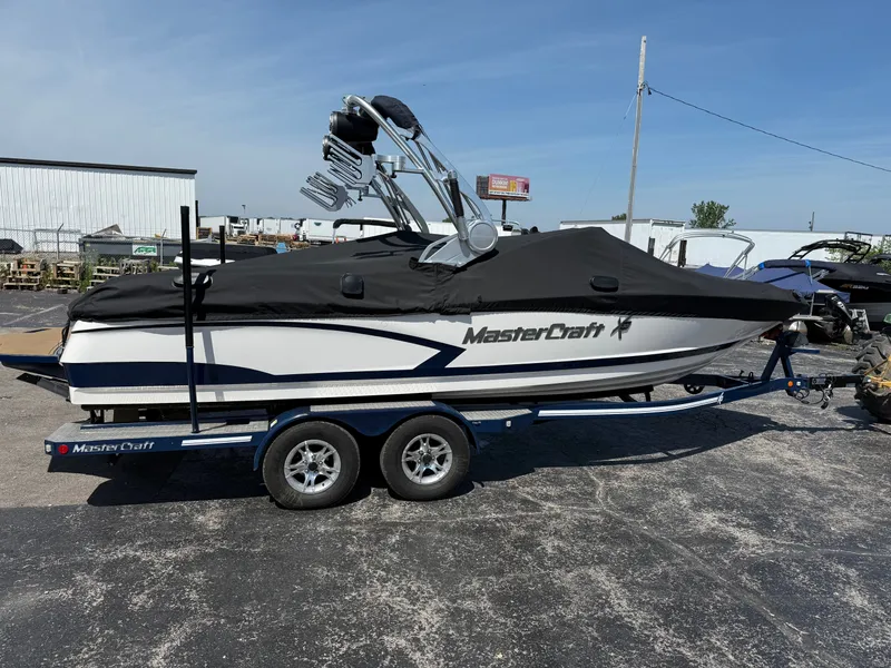 Slide: The Image of A 2016 MasterCraft X30 on a trailer, featuring a black cover and tower. - 4