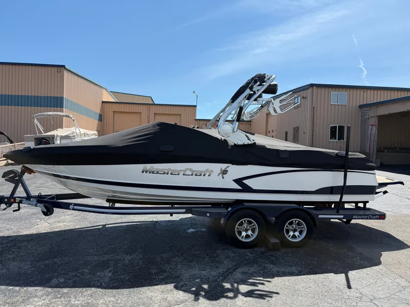 Slide: The Image of A 2016 MasterCraft X30 boat on a trailer, covered and parked in a storage area. - 2