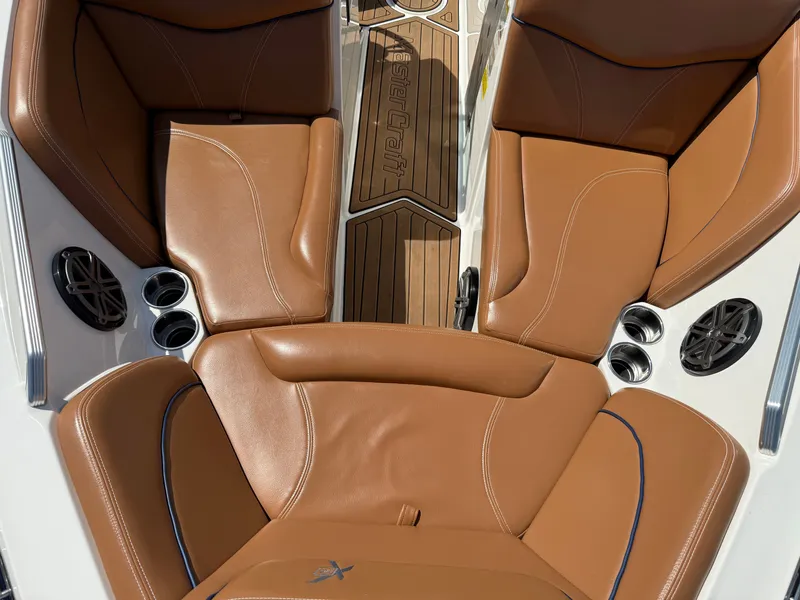 Slide: The Image of The image shows the brown leather seats of a 2016 MasterCraft X30 boat. - 35