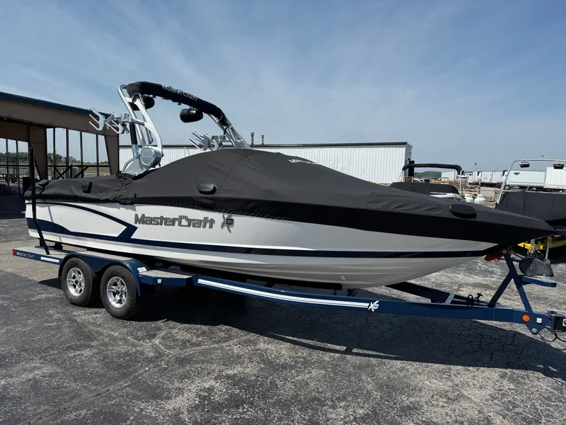 Slide: The Image of 2016 MasterCraft X30 on a trailer, covered in black, parked in a storage area. - 9
