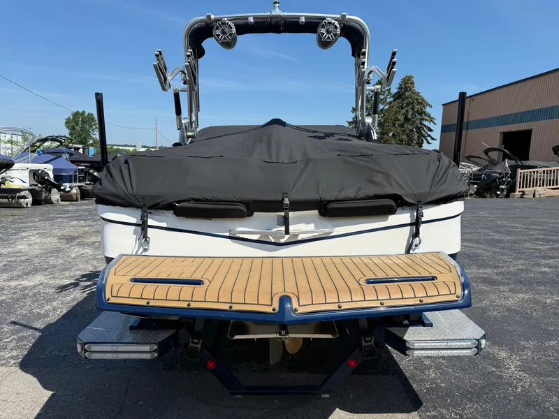 Slide: The Image of Rear view of a 2016 MasterCraft X30 boat with a black cover and wood accents. - 6
