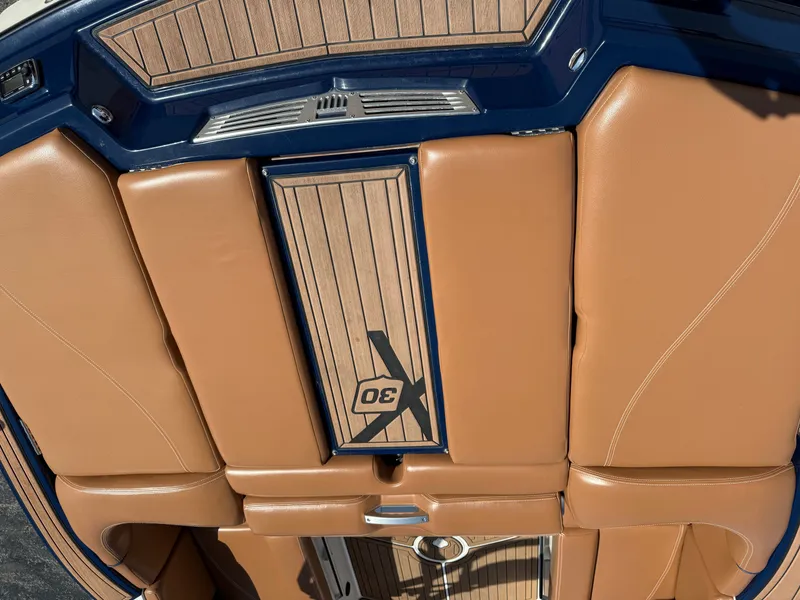 Slide: The Image of The image shows the cockpit of a 2016 MasterCraft X30 with brown upholstery and wood accents. - 25