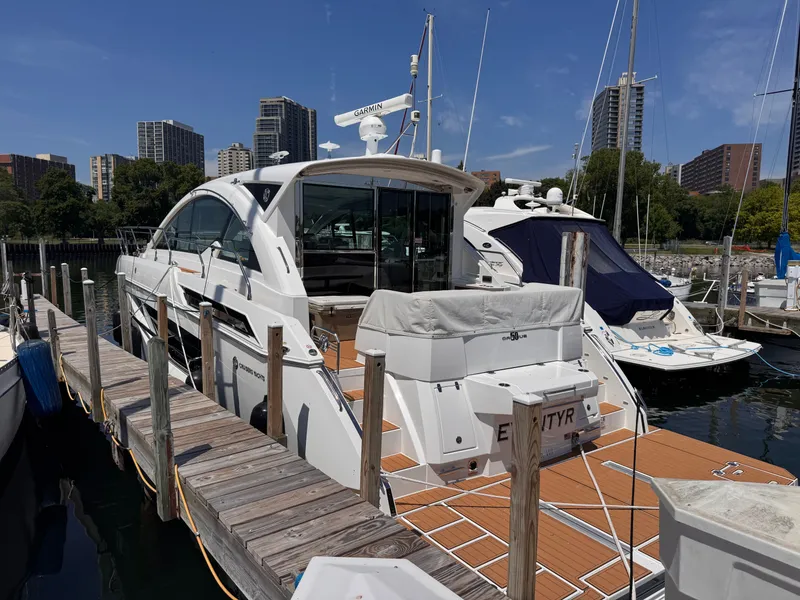 The Image of A luxury motor yacht docked at a wooden pier in a marina, surrounded by other boats. - 1