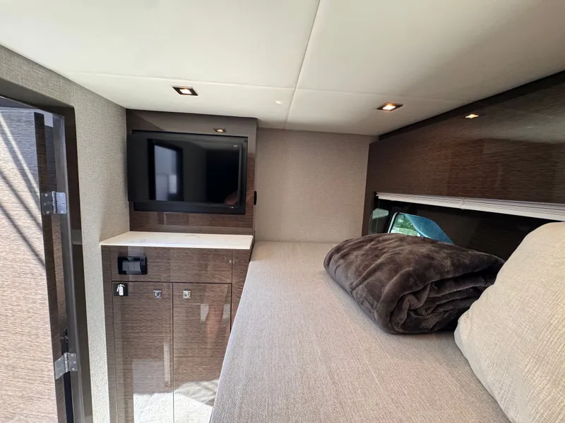 Slide: The Image of Interior of a 2021 Cruisers Yachts 50 Cantius featuring a TV and a bed. - 37