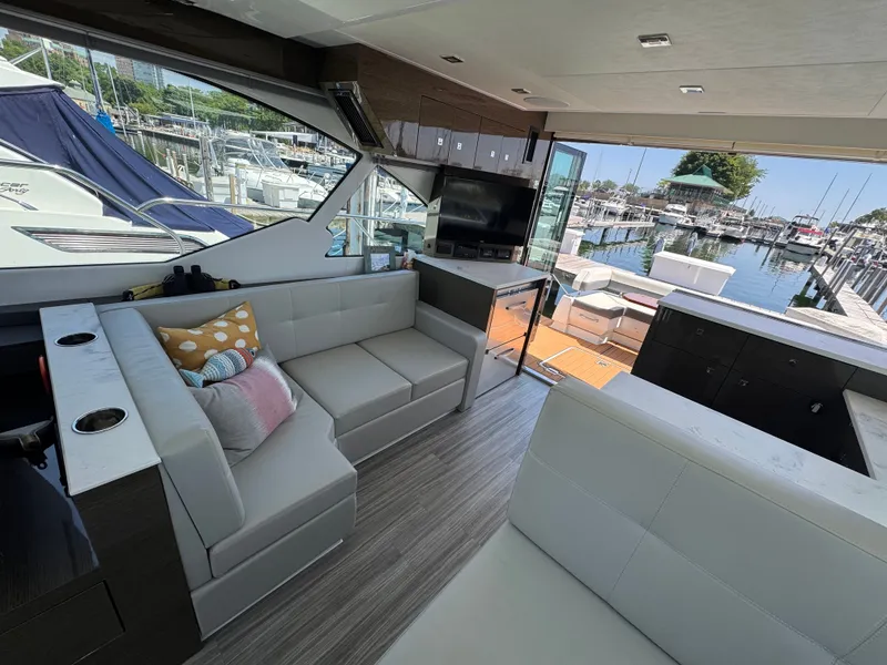 Slide: The Image of Interior of a luxury yacht with modern sofas and a TV, leading to a sunny deck. - 9