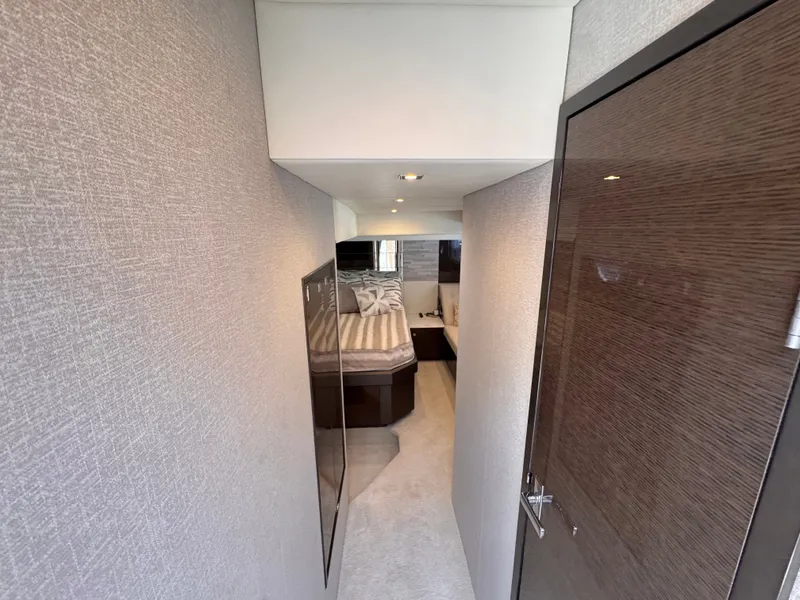 Slide: The Image of A narrow hallway leads to an elegant bedroom with a large bed and modern furnishings. - 21