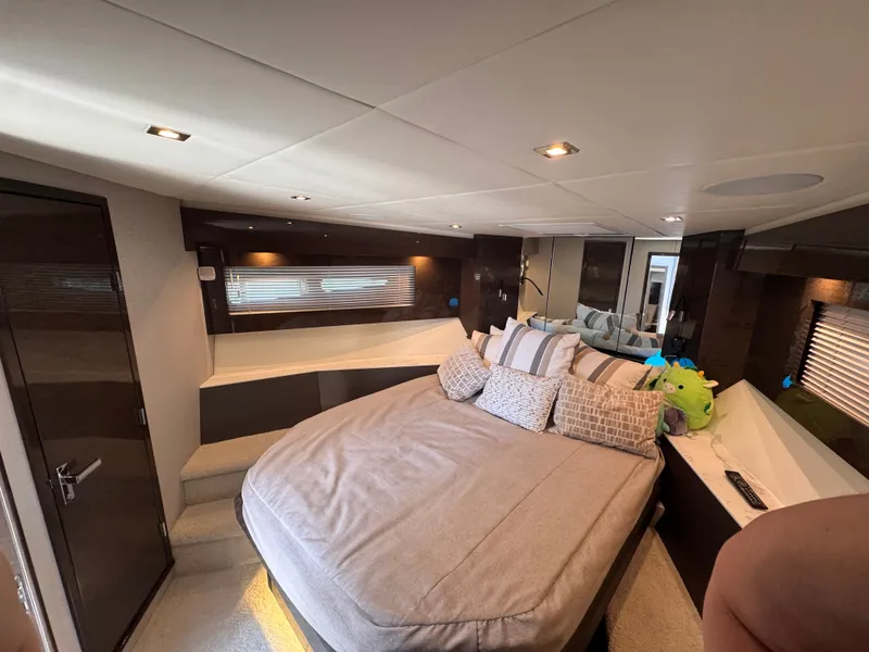 Slide: The Image of The 2021 Cruisers Yachts 50 Cantius cabin features a large bed, modern lighting, and sleek wood accents. - 31