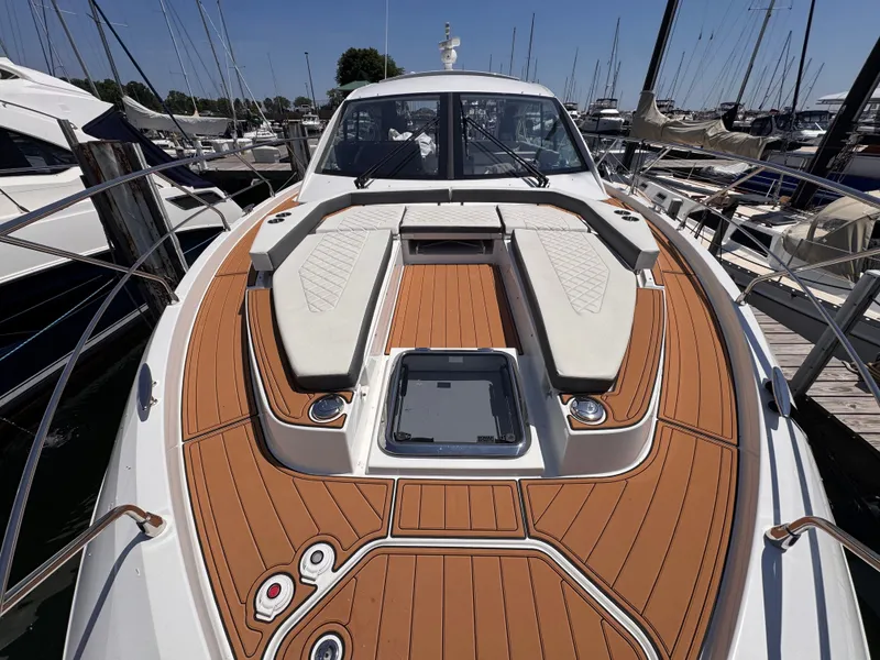 Slide: The Image of 2021 Cruisers Yachts 50 Cantius with sleek wood finish and comfortable seating areas at the dock. - 43