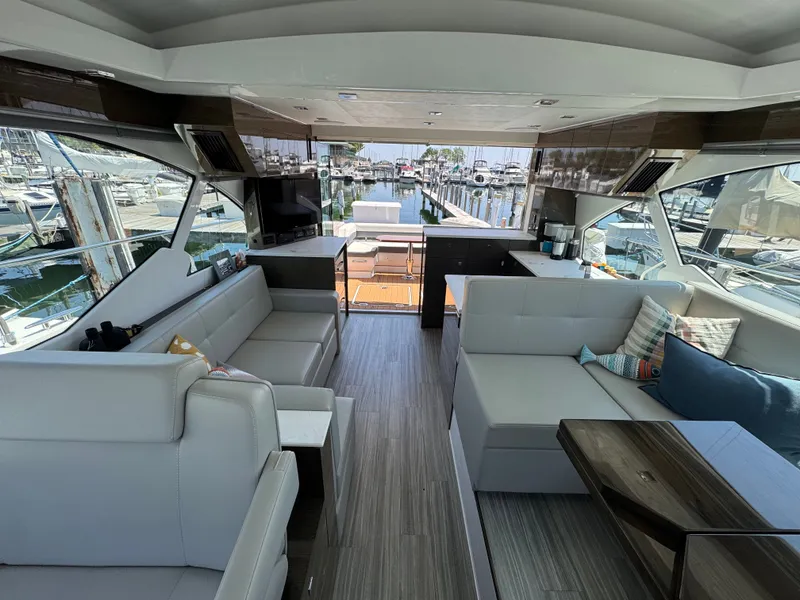 Slide: The Image of Interior of a luxury yacht with modern gray sofas and wood flooring, overlooking a marina. - 17