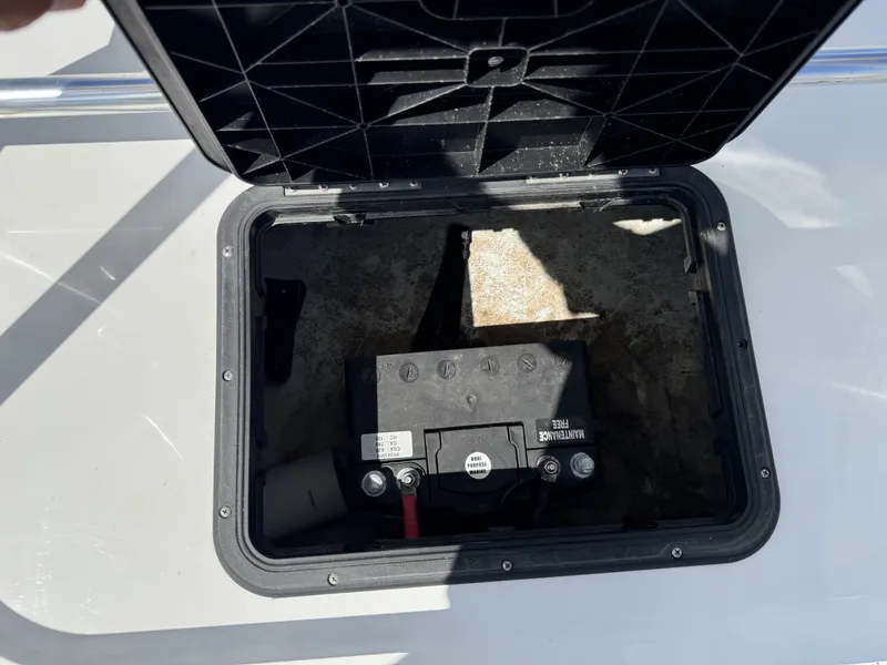 Slide: The Image of An open compartment on a boat reveals a battery and cables. - 18