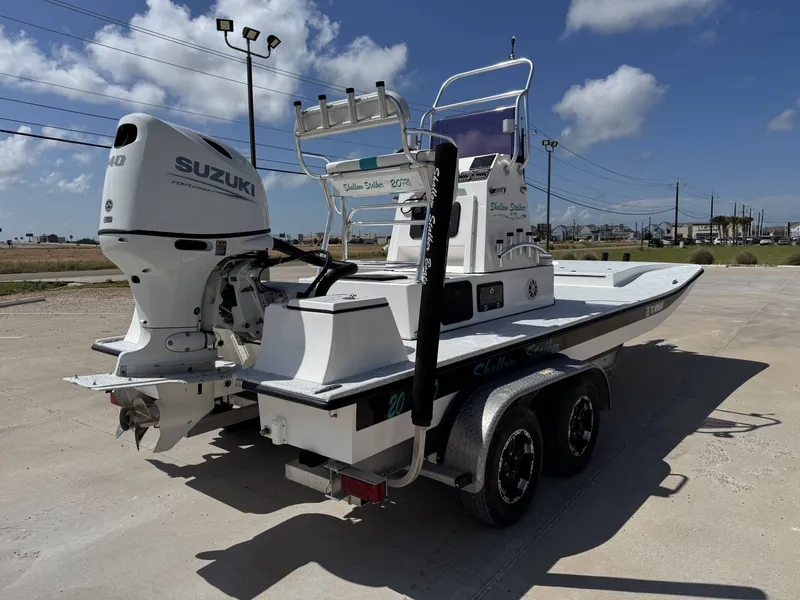 Slide: The Image of A 2024 Shallow Stalker 20 PRO boat on a trailer, featuring a Suzuki outboard motor. - 8