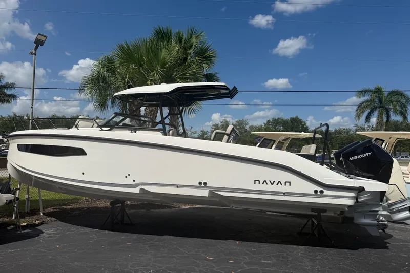 Slide: The Image of 2026 Navan S30 boat displayed outdoors with palm trees and blue sky background. - 2