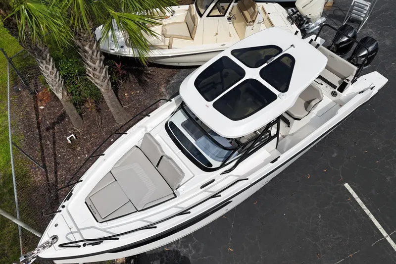 Slide: The Image of 2026 Navan S30 boat with sleek design, spacious seating, and modern features, docked near palm trees. - 6