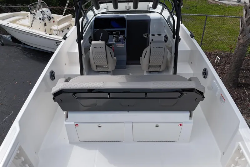 Slide: The Image of 2026 Navan S30 boat interior with seating and control panel, docked beside another boat. - 4