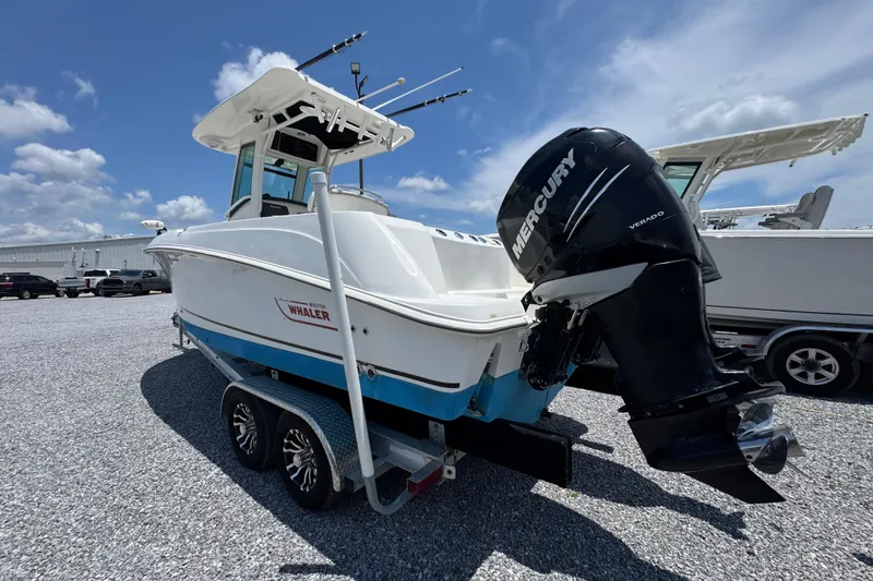 Slide: The Image of 2014 Boston Whaler 250 Outrage boat with Mercury engine on trailer, under clear sky. - 15