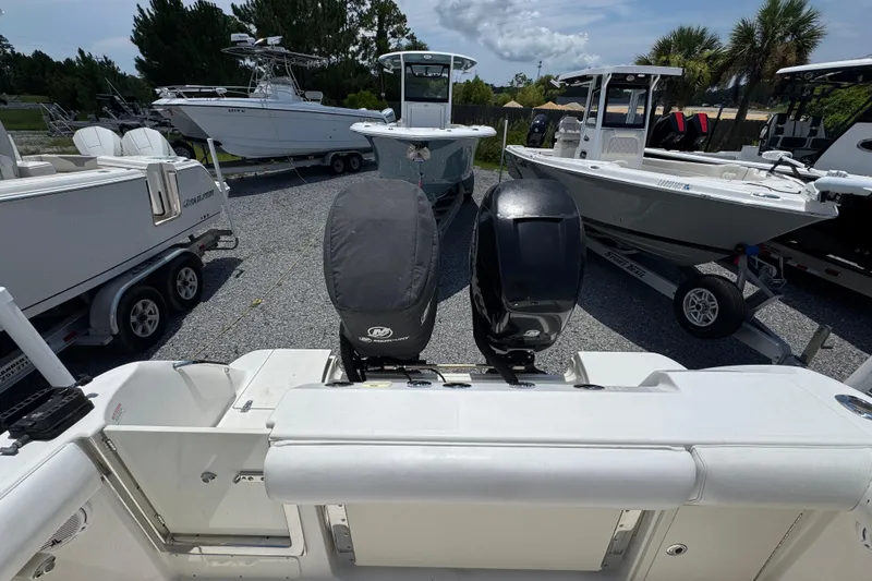 Slide: The Image of 2014 Boston Whaler 250 Outrage with dual outboard motors in a boatyard. - 37
